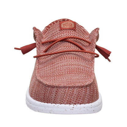 Front toe view of a men's Dude Wally Stretch Sox mesh shoe in Burnt Red with elastic laces, white speckled sole and Hey Dude logo patch on the tongue.