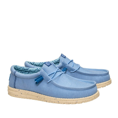 A pair of men's Dude Wally Stretch Canvas lightweight shoes in Faded Denim Blue / Boulder Tan, with elastic laces and speckled soles.