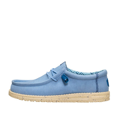 Side view of a men's Dude Wally Stretch Canvas lightweight shoe in Faded Denim Blue / Boulder Tan, with elastic laces and a speckled sole.