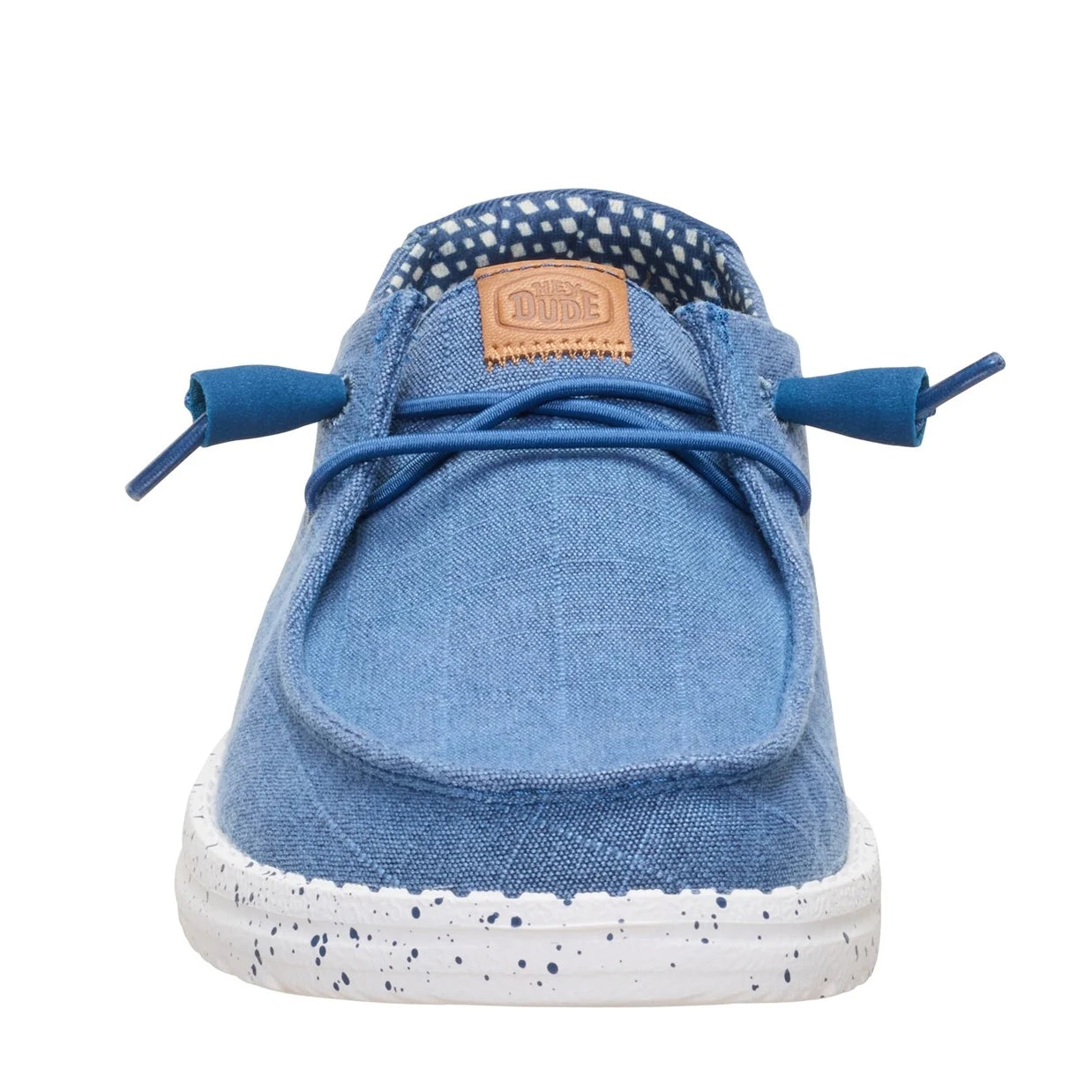 Front toe view of a women's Dude Wendy Chambray Grid shoe in Ensign Blue, featuring matching blue elastic laces, speckled white sole and Hey Dude logo on the tongue.