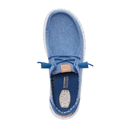 Top view of a women's Dude Wendy Chambray Grid shoe in Ensign Blue, featuring matching blue elastic laces and removable insole with Hey Dude logo.