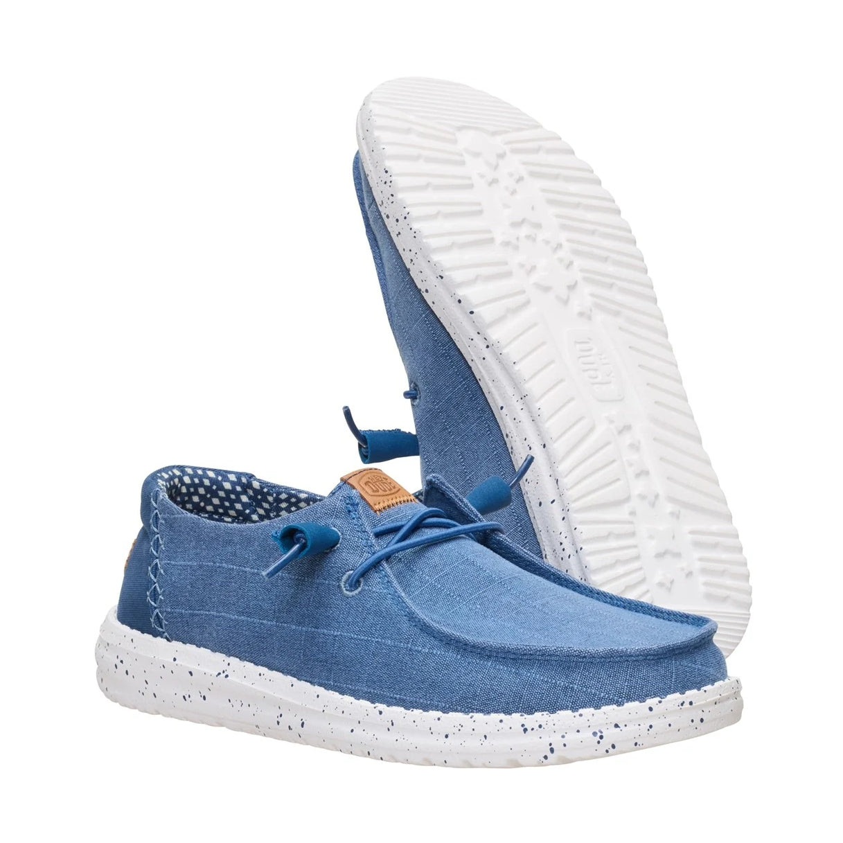 A pair of women's Dude Wendy Chambray Grid shoe in Ensign Blue, with one shoe showing the plain white outsole.