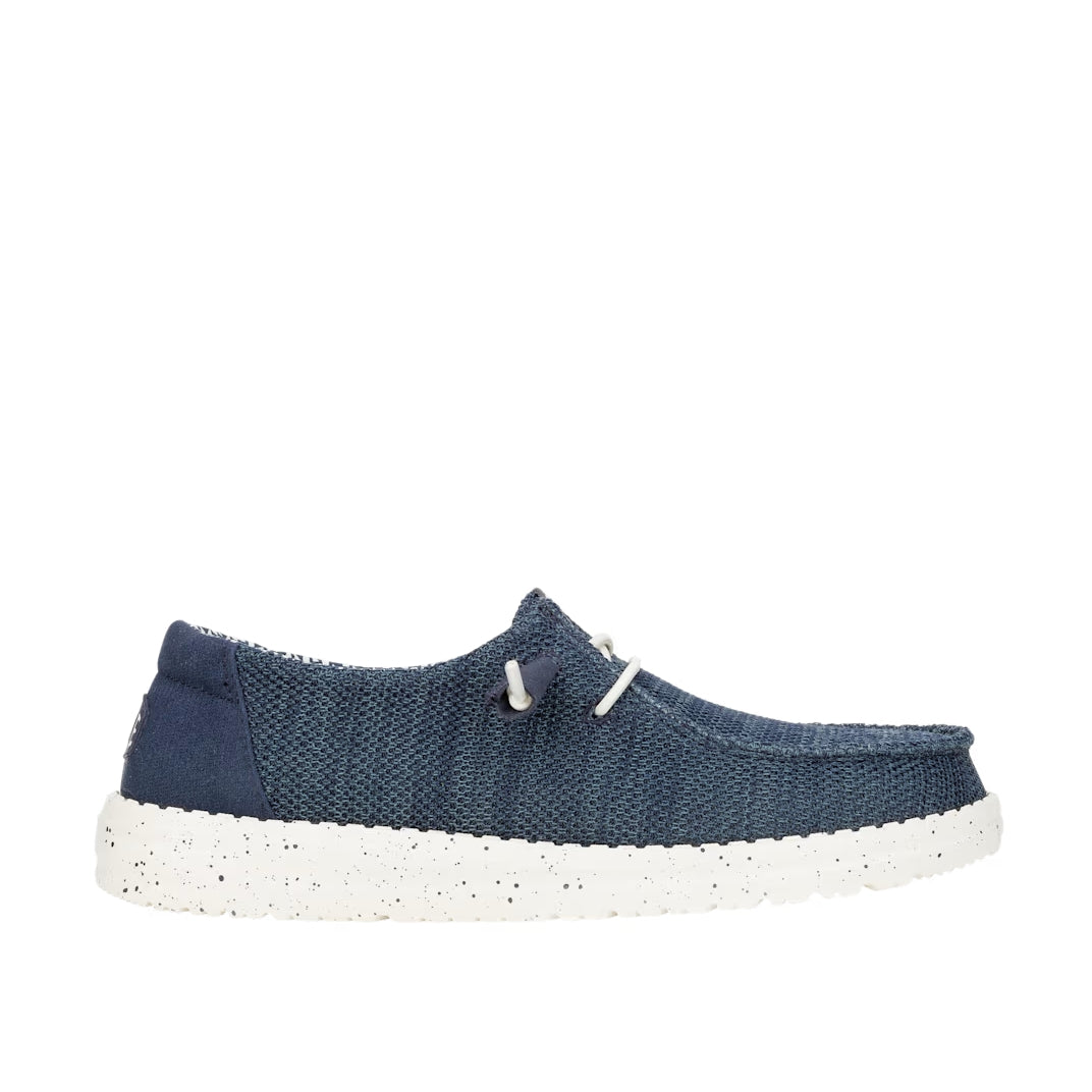 Side view of a women's Dude Wendy Stretch Sox shoe in Navy, featuring a white sole, elastic laces and plain brown heel panel.
