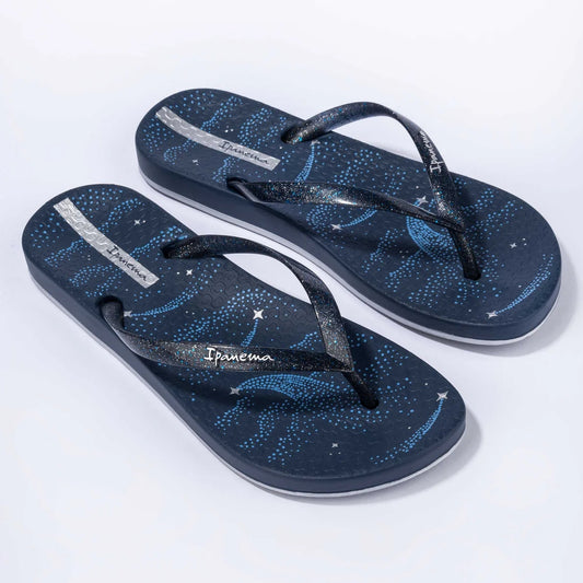 Main front view of a pair of women's Ipanema Anatomic Magic Fem flip flops in navy blue / silver, featuring a shooting star print footbed and glittery strap.