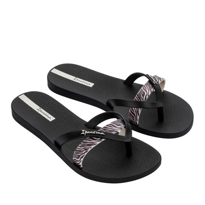 Main front view of a pair of women's Ipanema Kirei flip flops, a three strap toepost design in black with a contrasting zebra print strap.