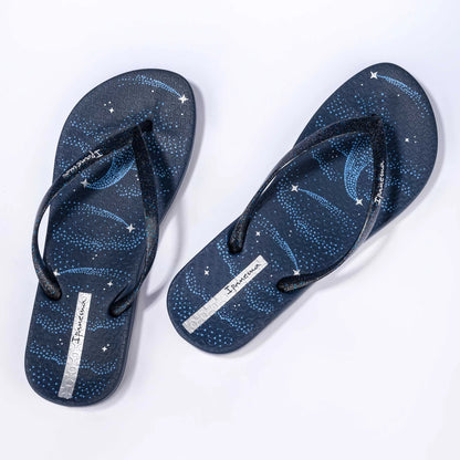 Top view of a pair of women's Ipanema Anatomic Magic Fem flip flops in navy blue / silver, featuring a shooting star print footbed and glittery strap with logo print.