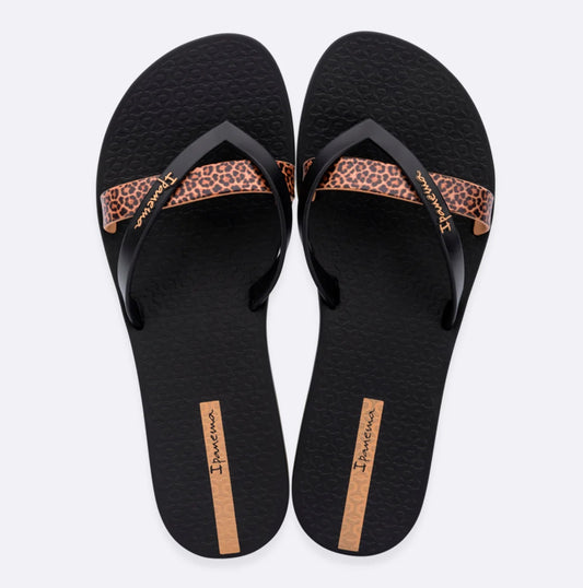 Top view of a pair of women's Ipanema Kirei flip flops, a three strap toepost design in black with a contrasting leopard print strap and textured footbed.