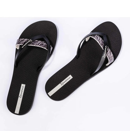 Top view of a pair of women's Ipanema Kirei flip flops, a three strap toepost design in black with a contrasting zebra print strap.