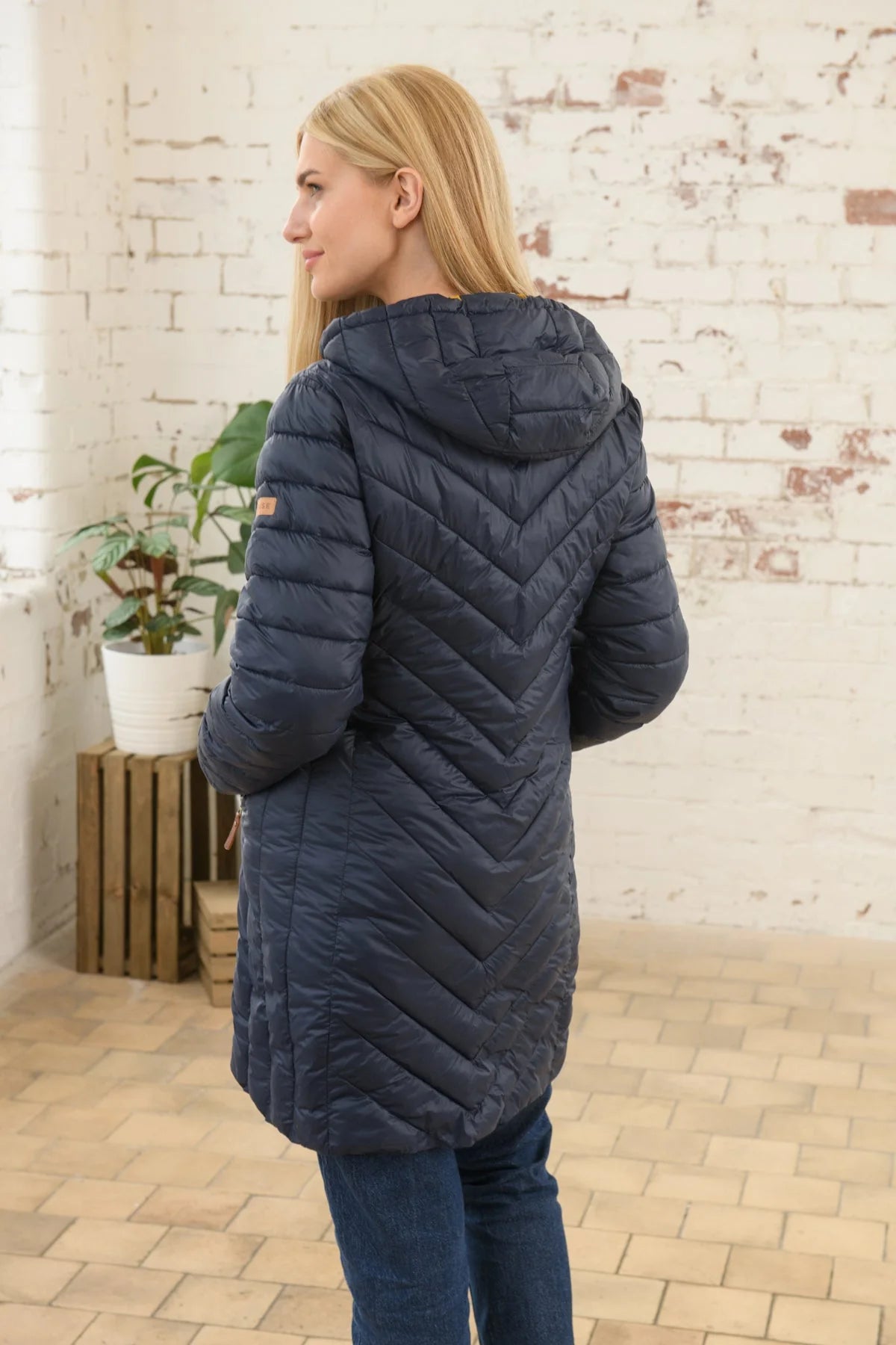 A navy padded women's Laurel coat by Lighthouse clothing.