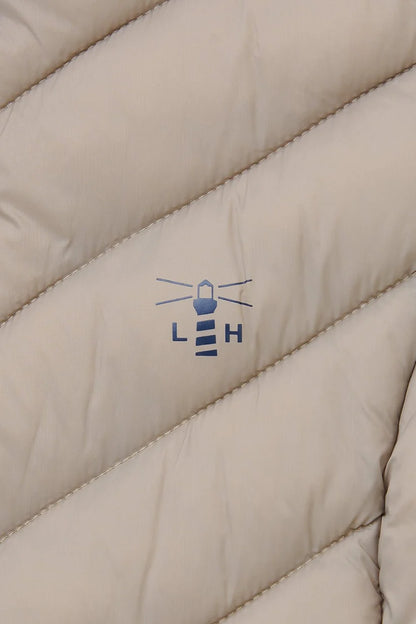 close up of lighthouse logo in navy on mocha gilet  