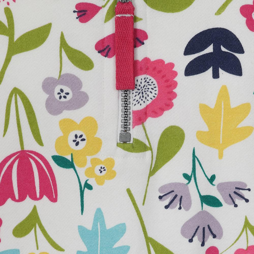 Close-up view of the zip of a kids Lazy Jacks LJ35CP 1/4 zip sweatshirt in white with a vibrant multicolour floral 'Bouquet' print.