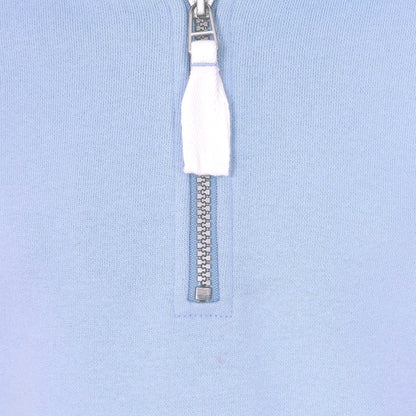 Close-up of Lazy Jacks kids sweatshirt with quarter zip and white zipper pull on soft blue fabric