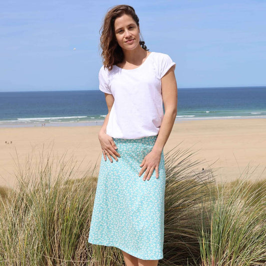 Front view of a woman wearing a Lazy Jacks LJ41 jersey skirt in turquoise with a white Buttercup floral pattern.