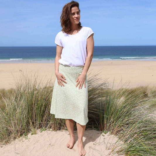 Front view of a woman wearing a Lazy Jacks LJ41 jersey skirt in a light shade of Grass Green with a delicate white floral pattern.