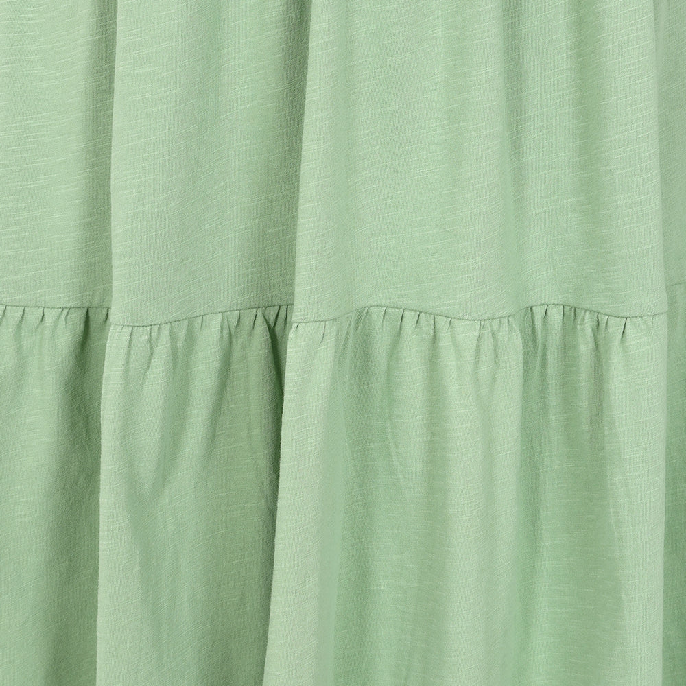 Close-up view of the tiered fabric of a Lazy Jacks LJ524 short sleeve dress in grass green.