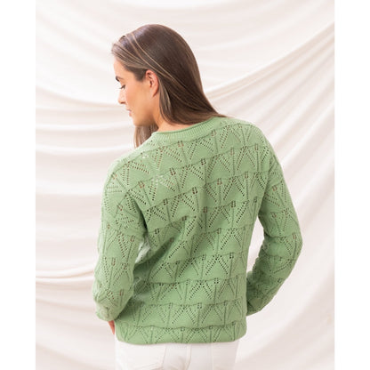 Back view of a woman wearing a Lighthouse Eden knitted jumper in Soft Sage Green with a geometric pointelle knit pattern.