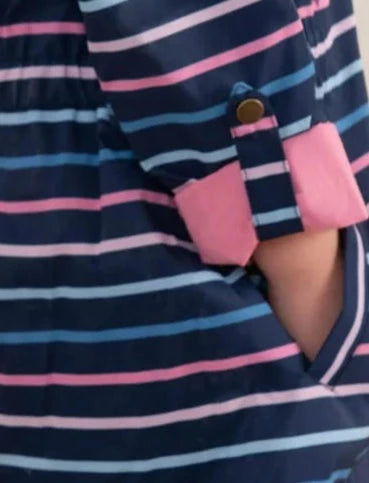 Close up of a kids Lighthouse navy, blue and pink stripe waterproof Charlotte jacket with button back sleeve and side pocket.
