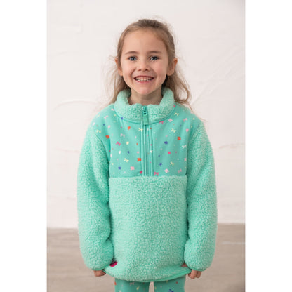 Main front view of a girl wearing a Lighthouse Cassie fleece, in mint green with a tiffany bows, hearts, stars and floral print on the chest.