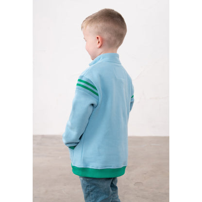 Back view of a child wearing a Lighthouse Jonah zip neck sweatshirt in sky blue with green trim and tractor applique on the chest.