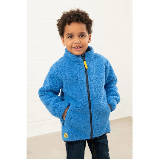 Child wearing a blue Lighthouse Kian sherpa fleece jacket with a white background
