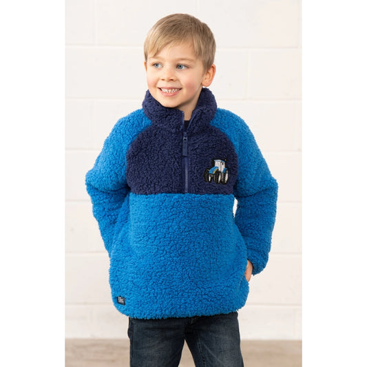Child wearing a blue and navy Lighthouse Caden fleece pullover with a tractor logo on a white background