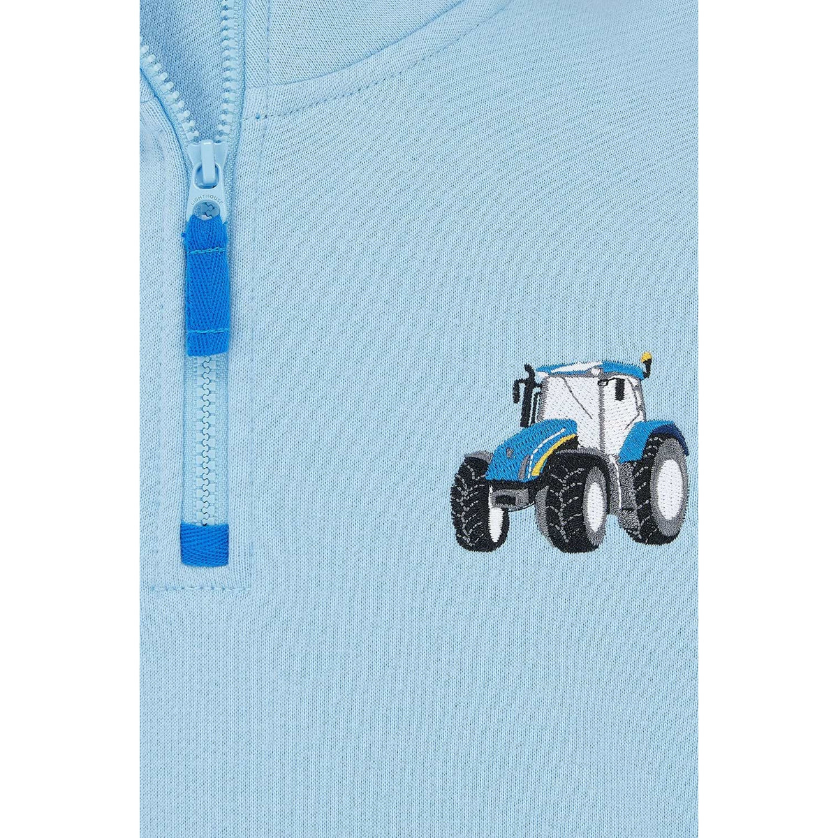 Close-up view of a Weird Fish kids Jonah 1/4 zip neck sweatshirt with blue trim and blue tractor applique sewn on the chest.