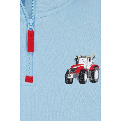 Close-up view of a Lighthouse kids Jonah 1/4 zip sweatshirt in sky blue with red trim and a red embroidered tractor applique on the chest.
