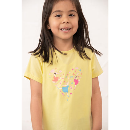 Close-up view of a girl wearing a kids Lighthouse short sleeve Causeway t-shirt in lemon yellow, featuring a heart shape ballerina print on the front.
