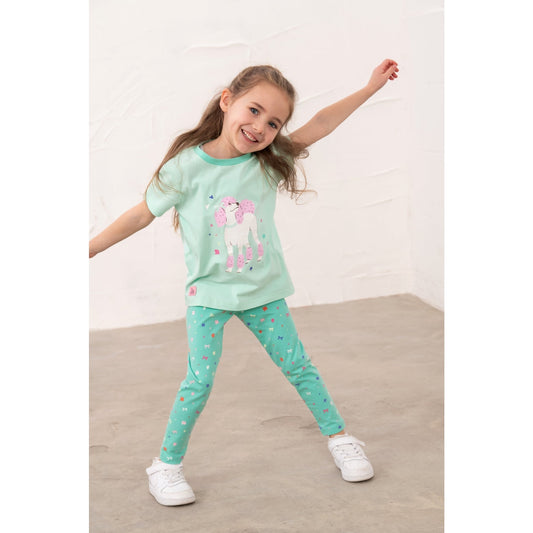 A girl wearing a pair of Lighthouse kids Mollie leggings in mint green with a bows, stars and floral pattern and a poodle print t-shirt.