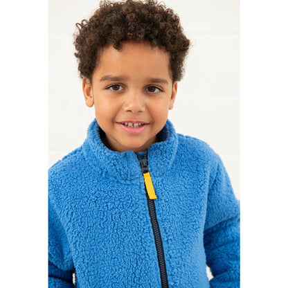 Child wearing a blue Lighthouse Kian fleece jacket with a yellow zipper on a white background