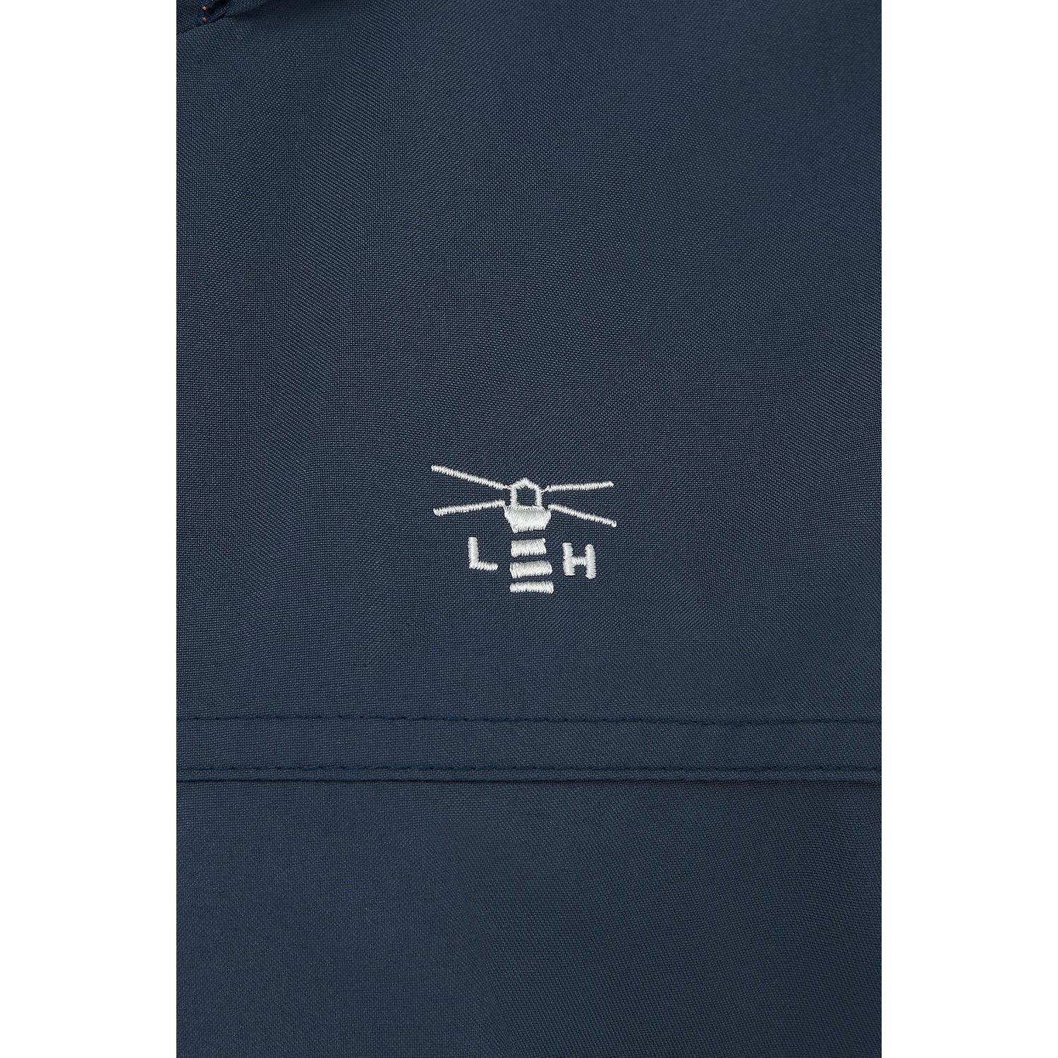 Close-up view of the logo and fabric of a women's Lighthouse Beachcomber II waterproof jacket in Navy.