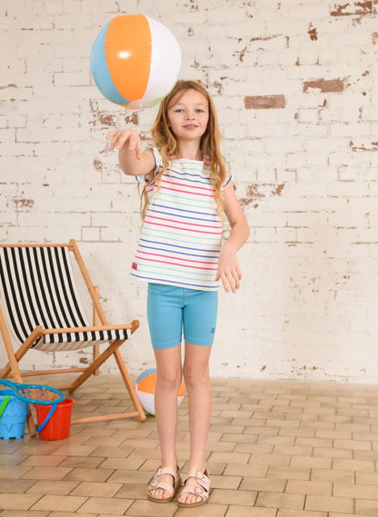 Young girl wearing Lighthouse Polly Shorts Turquoise playing with a beach ball indoors