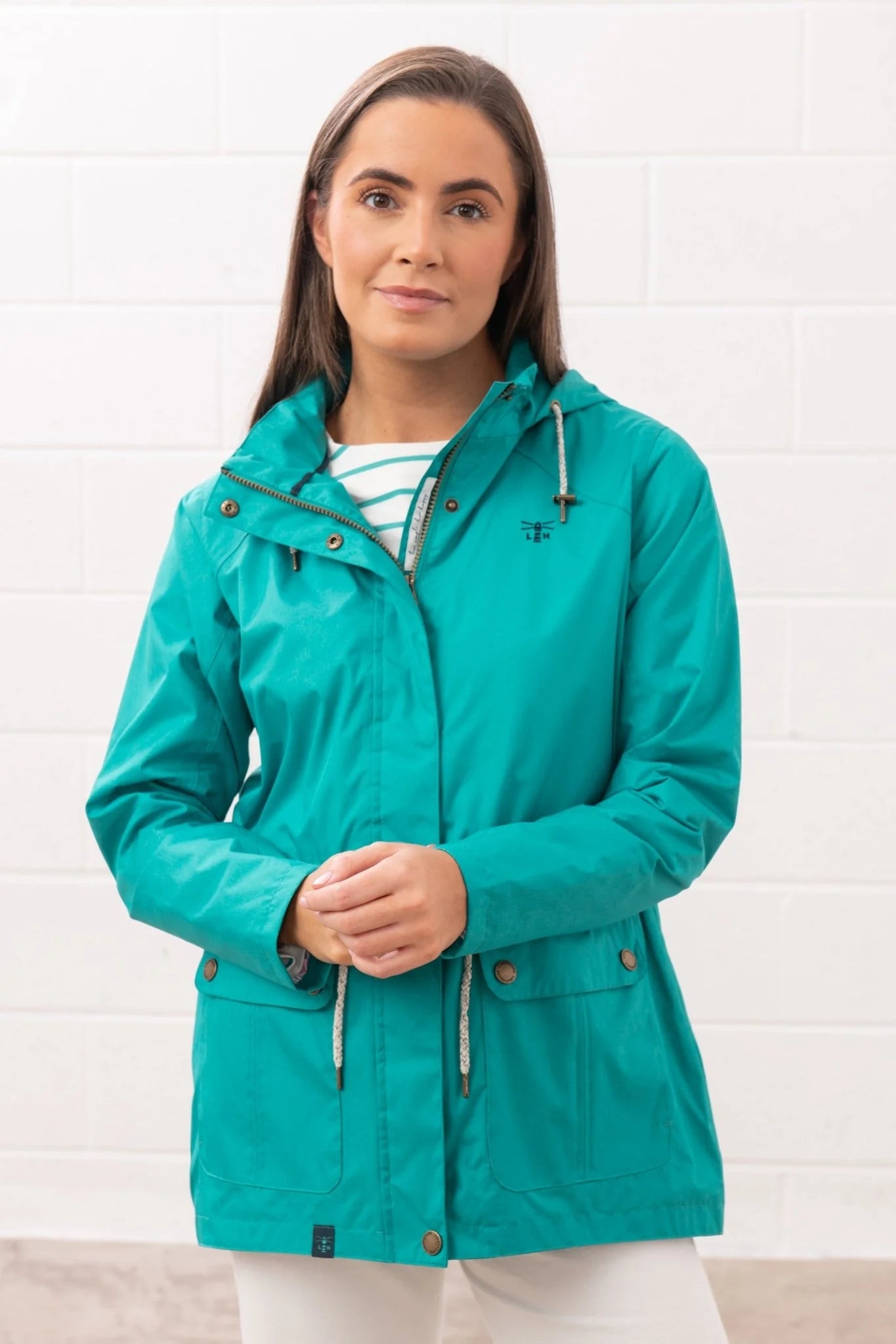 Lighthouse teal womens waterproof jacket with hood and front pockets worn by model