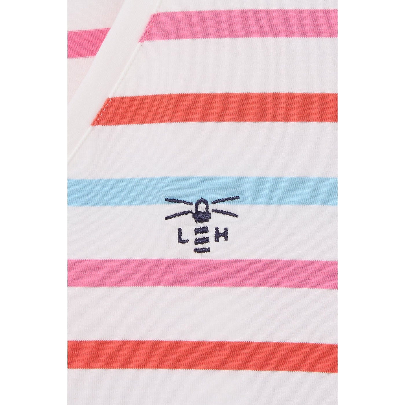 Closeup of a Watermelon Pink striped Lighthouse womens Ariana top with a logo and text on a white background