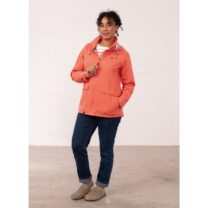 Front view of a woman wearing a Beachcomber II waterproof jacket in Coral.