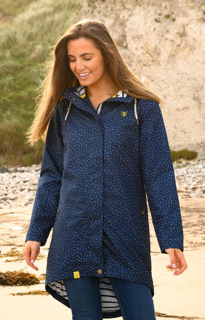 Lighthouse womens beachcomber jacket navy dot worn by smiling woman on beach with hood and dotted pattern