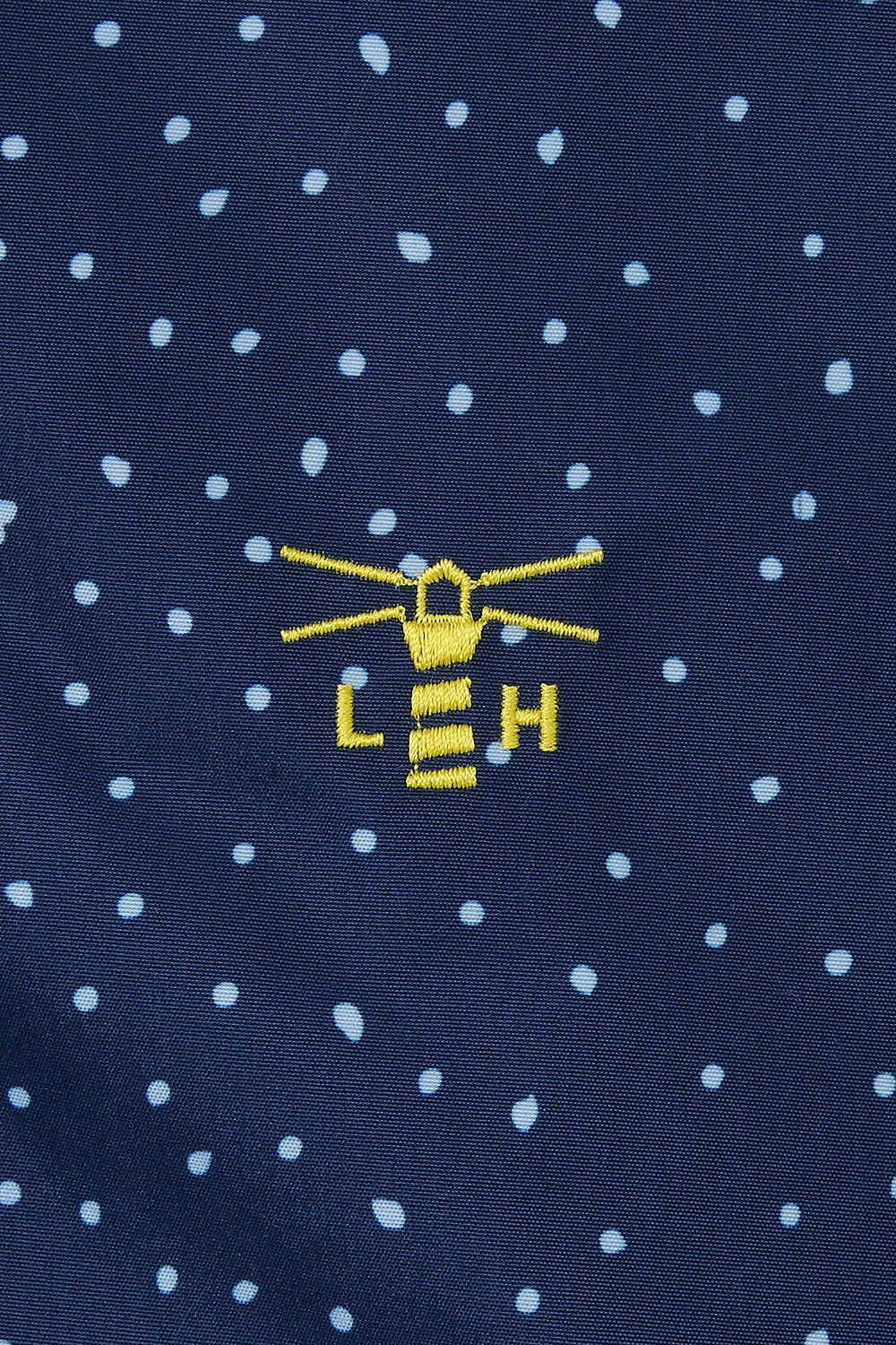 Close-up of lighthouse womens beachcomber jacket navy dot with embroidered yellow lighthouse logo