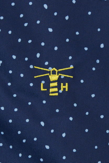 Close-up of lighthouse womens beachcomber jacket navy dot with embroidered yellow lighthouse logo