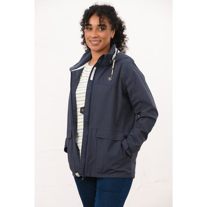 Side view of a woman wearing a Lighthouse navy Beachcomber waterproof jacket unzipped.