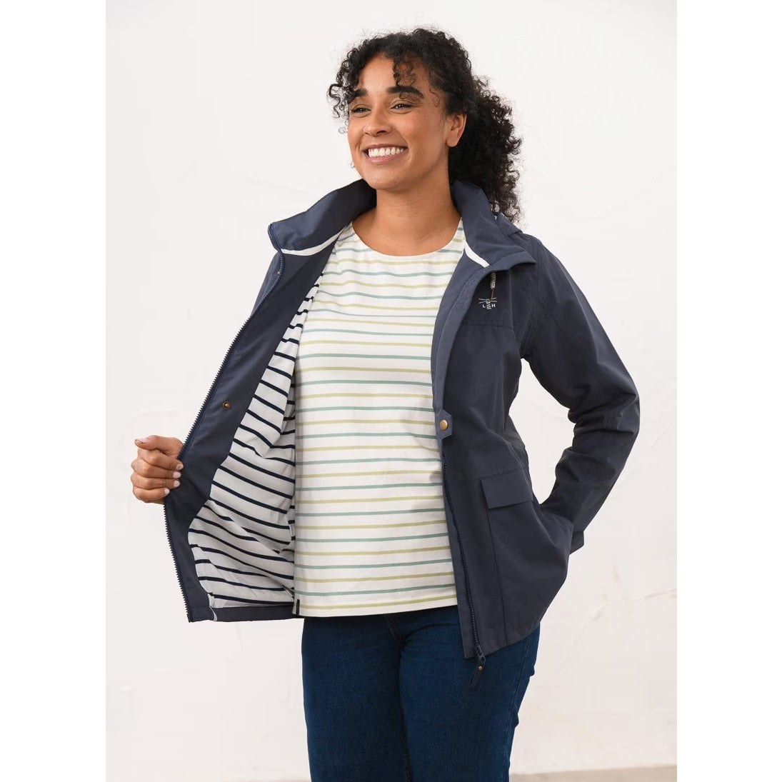 A woman wearing a Lighthouse navy Beachcomber II waterproof jacket showing the stripy lining.