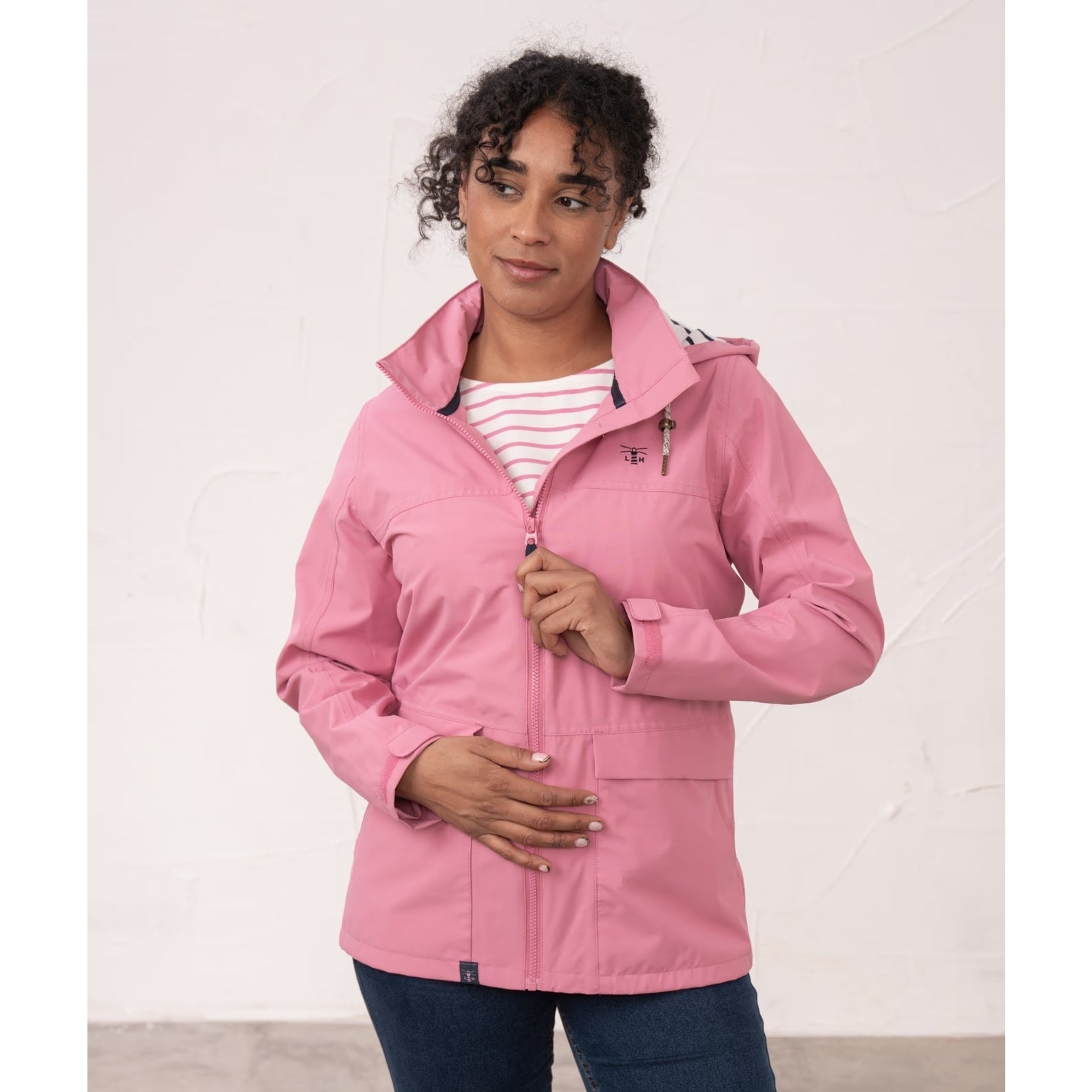 Front view of a woman wearing a Beachcomber II waterproof jacket in Pink.