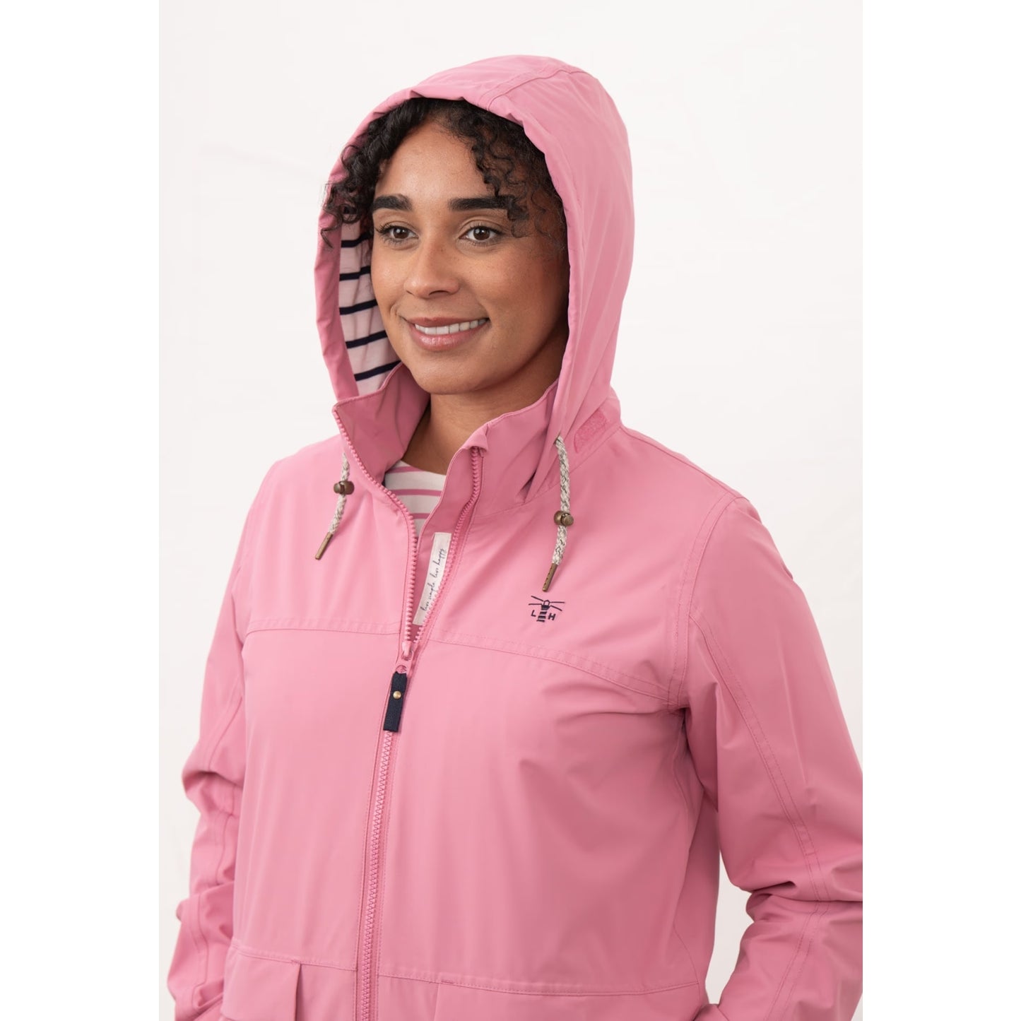 Close-up view of a woman wearing a Beachcomber II waterproof jacket in Pink with the hood up.