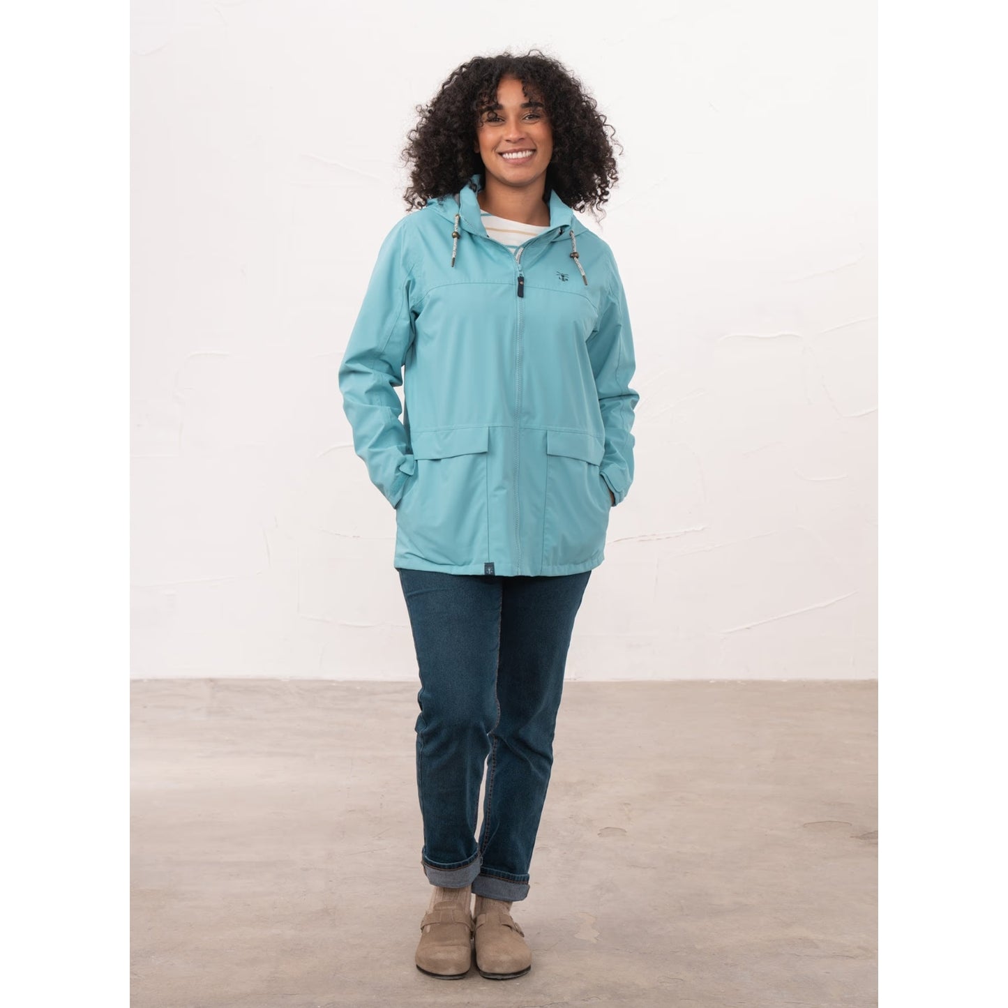 Front view of a woman wearing a Beachcomber II waterproof jacket in Blue with her hands in the side pockets.