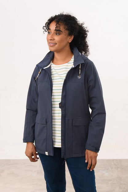 Front view of a woman wearing a Lighthouse Beachcomber II waterproof jacket in Navy unzipped.