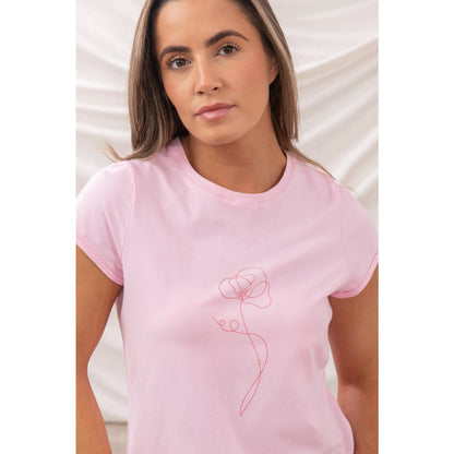Woman wearing a pink Lighthouse short sleeve Causeway t-shirt with a single flower print on a white background