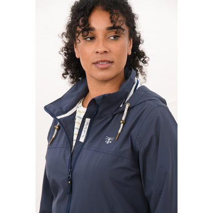Close-up view of a woman wearing a Lighthouse navy Beachcomber II waterproof jacket with drawstring hood.