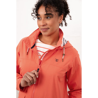 Close-up view of a woman wearing a Beachcomber II waterproof jacket in Coral with a stripy hood lining.