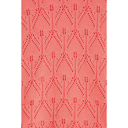 Close-up view of the pointelle crochet style knit of a womens Lighthouse Eden jumper in a bright Sugar Coral colour.