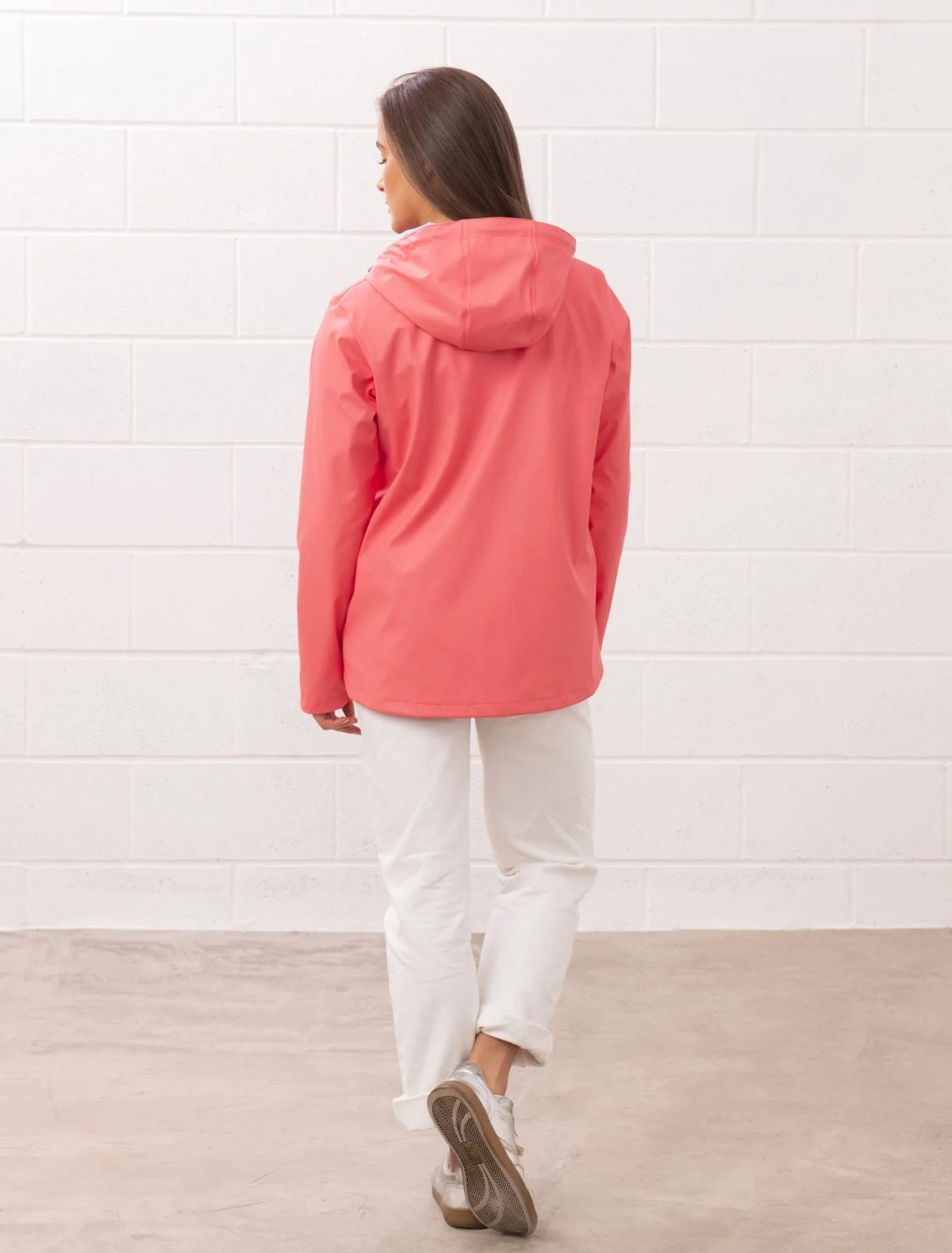 Lighthouse womens coral jacket back view with hood worn by model in white pants
