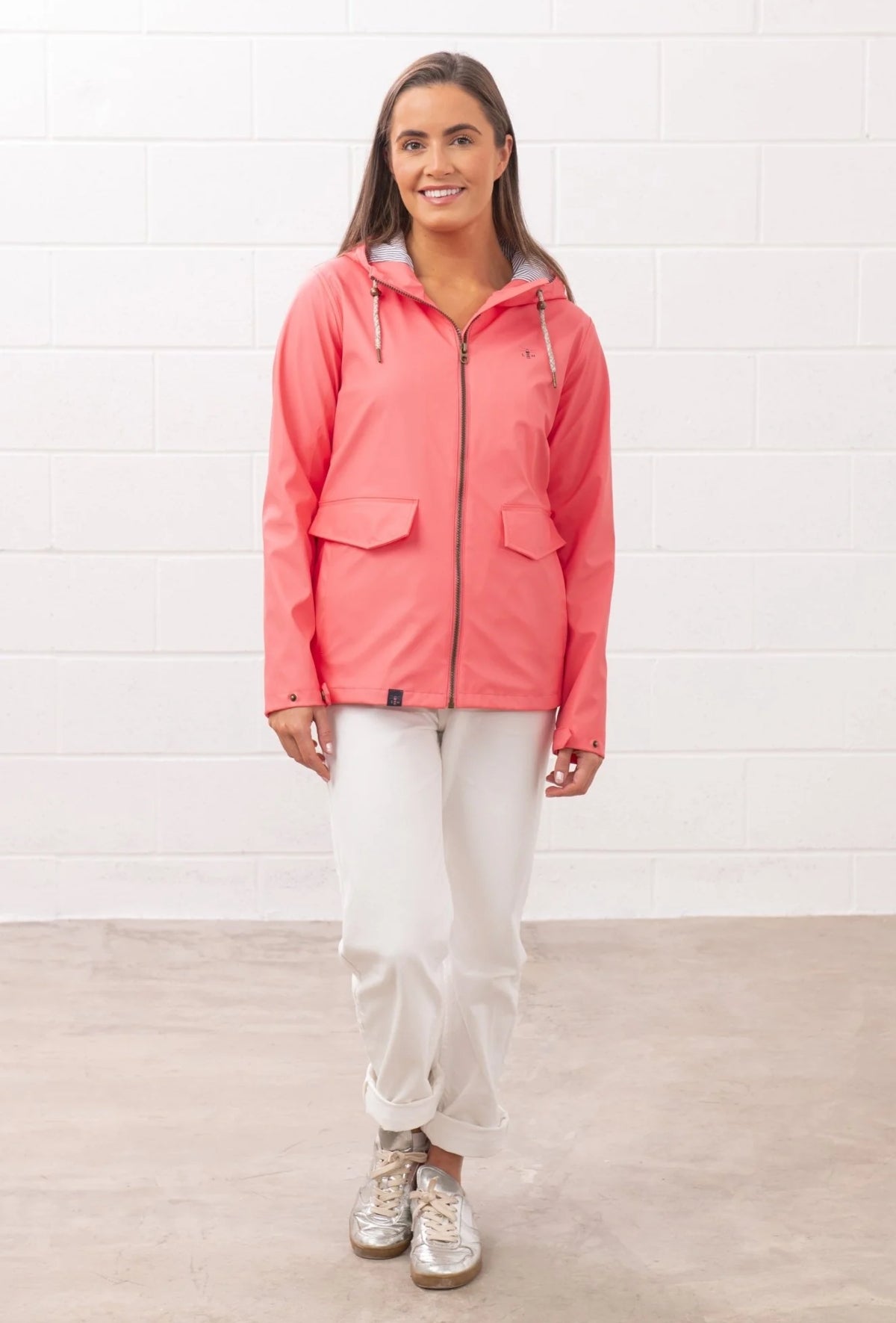 Lighthouse womens coral jacket with hood and front pockets worn by a smiling woman